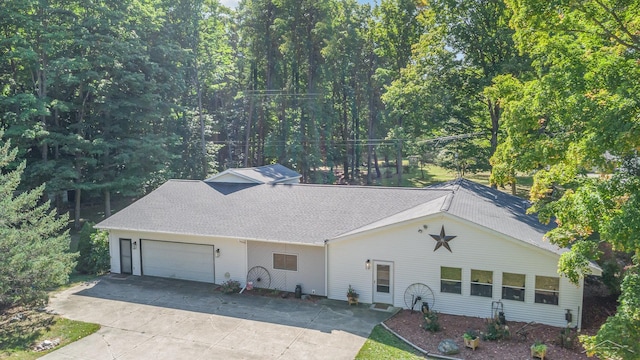 6610 E Arnold Lake Rd, Harrison, MI 48625 - traditional-style house featuring concrete driveway, an attached garage, and a shingled roof