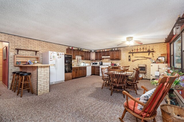 6610 E Arnold Lake Rd, Harrison, MI 48625 - carpeted dining area with brick wall, a ceiling fan, a brick fireplace, a sink, and a textured ceiling