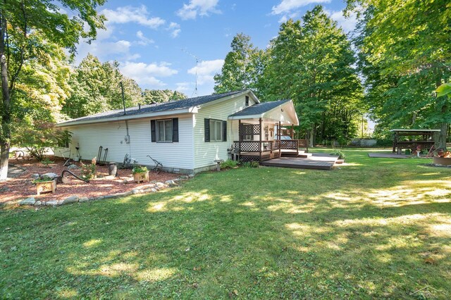 6610 E Arnold Lake Rd, Harrison, MI 48625 - back of property featuring a wooden deck and a lawn