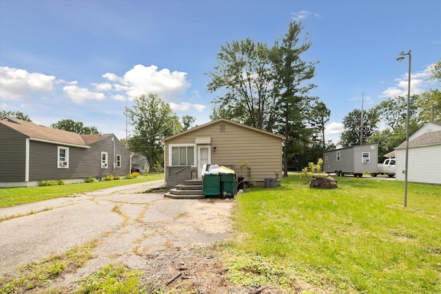 exterior space with central AC unit and a yard