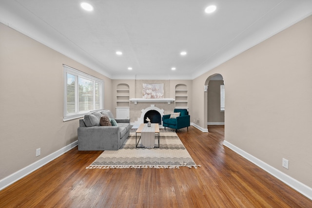 living room featuring built in features and dark wood-type flooring