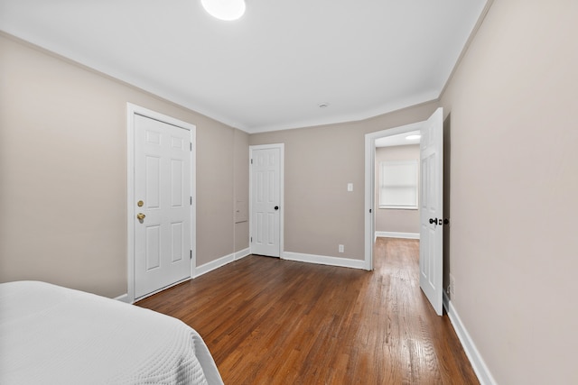 bedroom with dark hardwood / wood-style floors