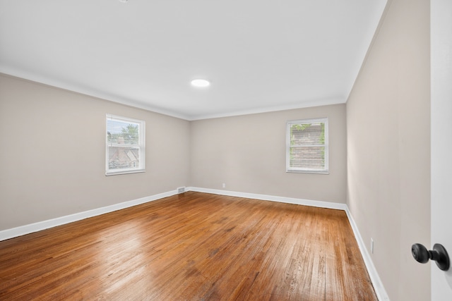 spare room with wood-type flooring and ornamental molding