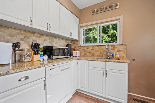 kitchen featuring white cabinets, sink, white dishwasher, and light hardwood / wood-style flooring