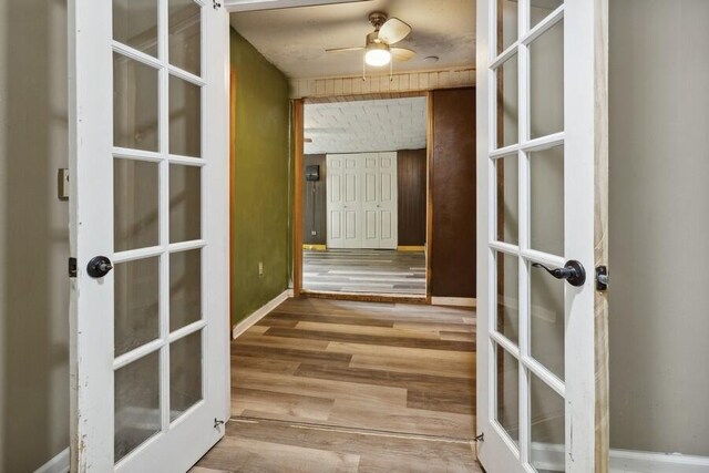 interior space with ceiling fan, wood-type flooring, and french doors