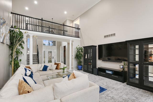 living room featuring ornate columns and a towering ceiling