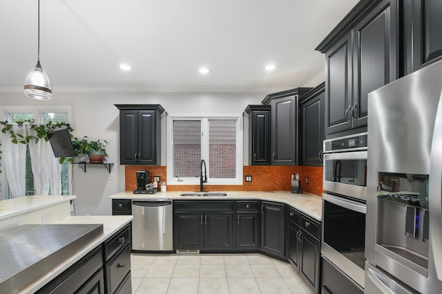 kitchen featuring sink, hanging light fixtures, crown molding, light tile patterned flooring, and appliances with stainless steel finishes