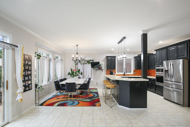 kitchen with a breakfast bar, stainless steel appliances, a chandelier, a kitchen island, and hanging light fixtures