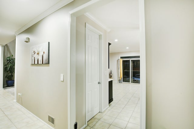 hall with crown molding and light tile patterned flooring