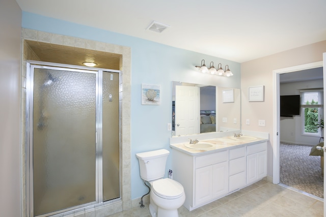 bathroom with tile patterned flooring, vanity, toilet, and a shower with shower door