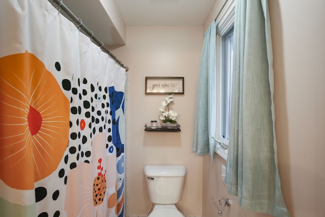 bathroom featuring a shower with curtain and toilet