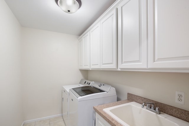 laundry room with cabinets, independent washer and dryer, light tile patterned floors, and sink