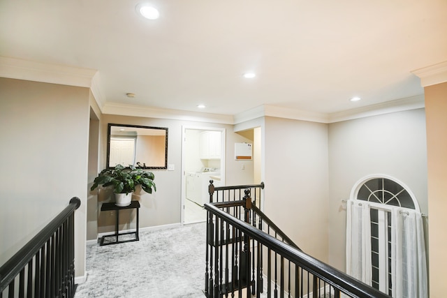 hall featuring light colored carpet, separate washer and dryer, and ornamental molding