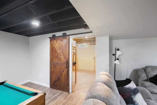 recreation room featuring a barn door, light hardwood / wood-style flooring, and billiards