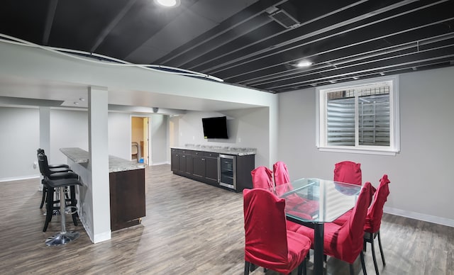 dining area featuring bar, dark hardwood / wood-style flooring, and beverage cooler