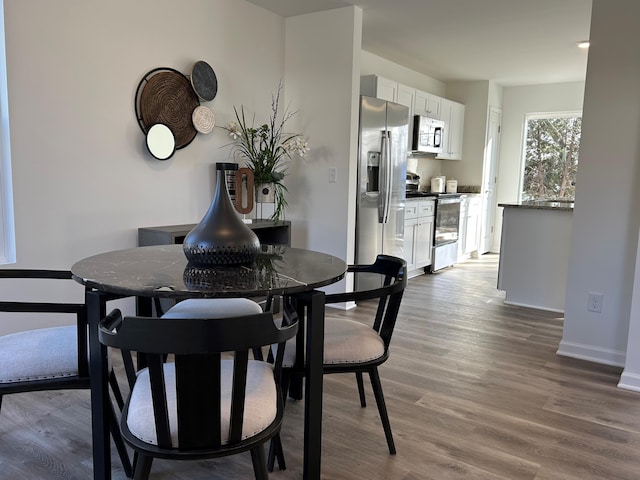 dining space with wood-type flooring