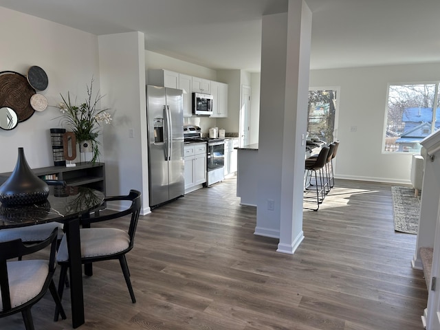 kitchen featuring stainless steel appliances, dark hardwood / wood-style floors, and white cabinets