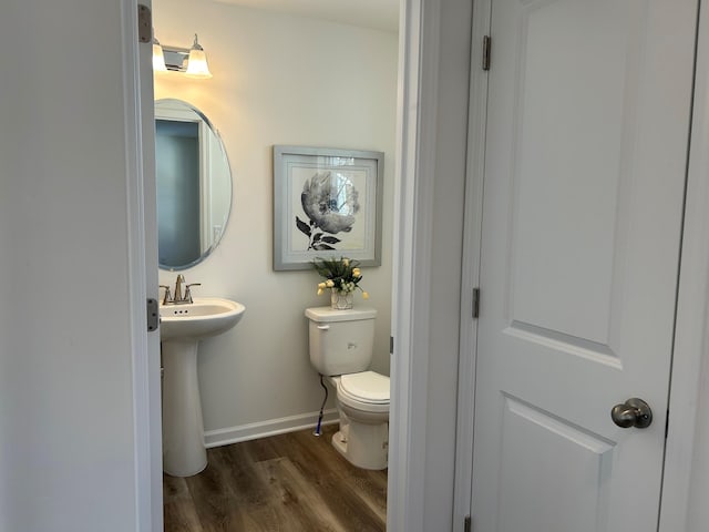 bathroom with hardwood / wood-style flooring, sink, and toilet