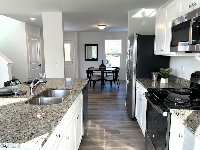 kitchen with white cabinetry, stainless steel appliances, sink, and light stone counters