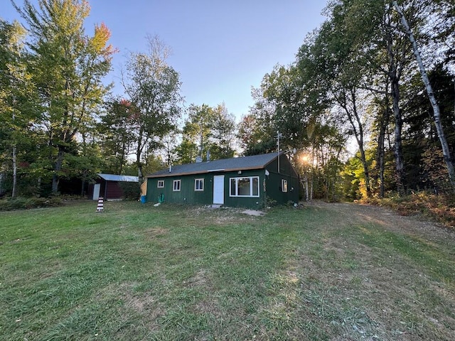 view of front of home featuring a storage shed and a yard