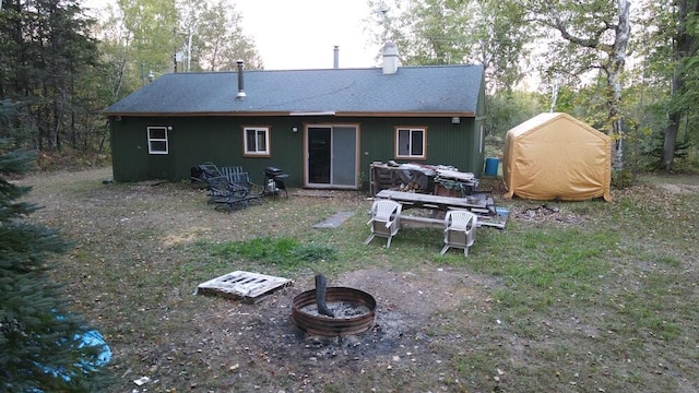 back of property with an outdoor fire pit