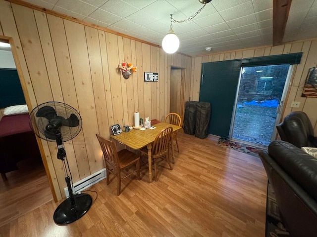 dining space featuring wooden walls and hardwood / wood-style flooring