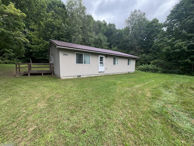 23920 Beers Rd, Mesick, MI 49668 - back of house featuring a view of trees, a lawn, metal roof, crawl space, and a wooden deck