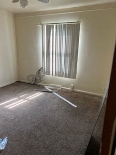 unfurnished room with ceiling fan and carpet floors