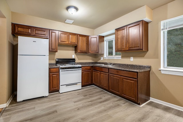 kitchen featuring sink, light hardwood / wood-style floors, and white appliances