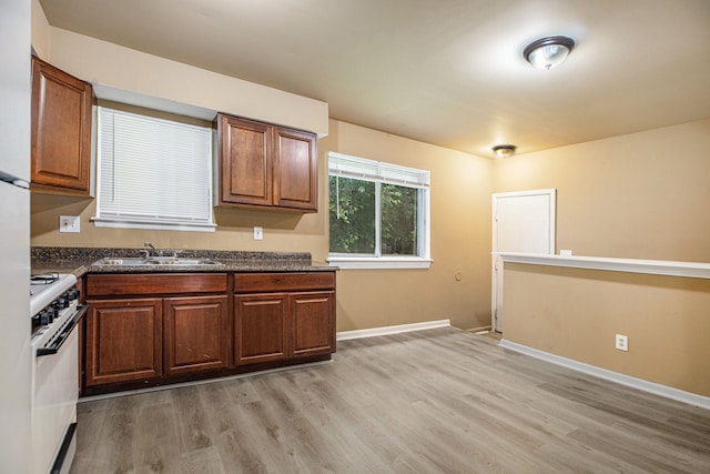 kitchen featuring sink, white stove, and hardwood / wood-style flooring