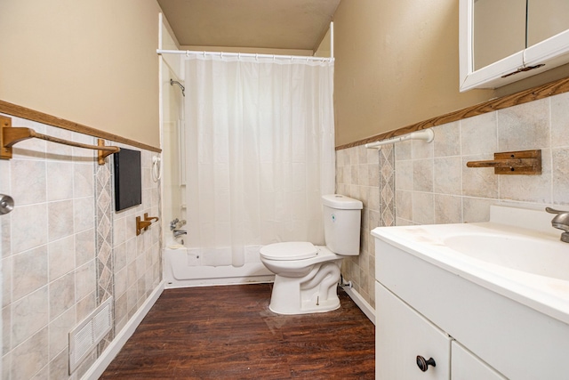 full bathroom with shower / tub combo, wood-type flooring, tile walls, and toilet