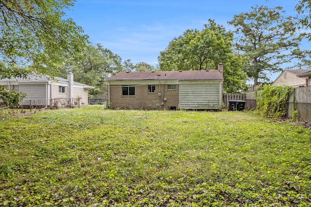 rear view of house featuring a yard