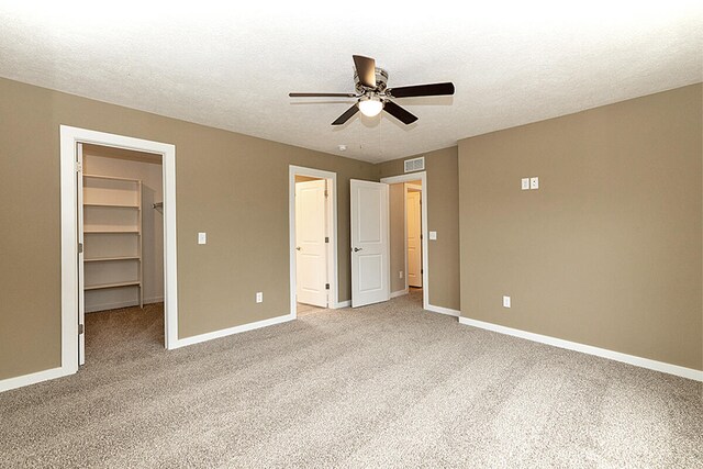 unfurnished bedroom with visible vents, baseboards, and a spacious closet