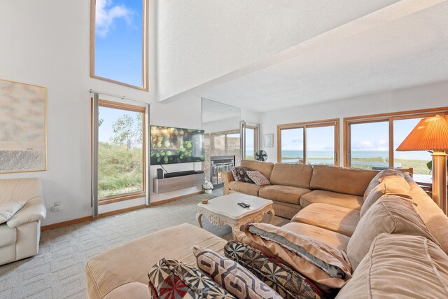 300 Marquette Dr, New Buffalo, MI 49117 - living area featuring light carpet, a tiled fireplace, baseboards, and a towering ceiling