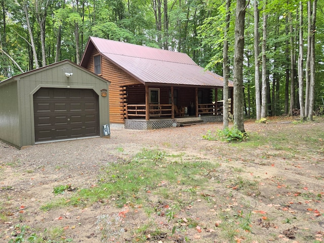 log-style house featuring a garage and an outbuilding