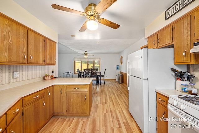 kitchen featuring kitchen peninsula, white range, light hardwood / wood-style floors, and ceiling fan