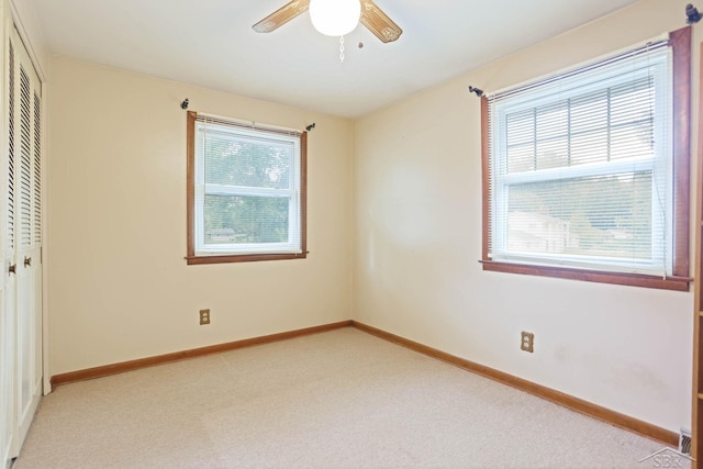 unfurnished bedroom with multiple windows, ceiling fan, and a closet