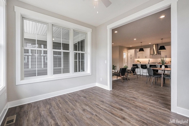 interior space with ceiling fan and dark wood-type flooring