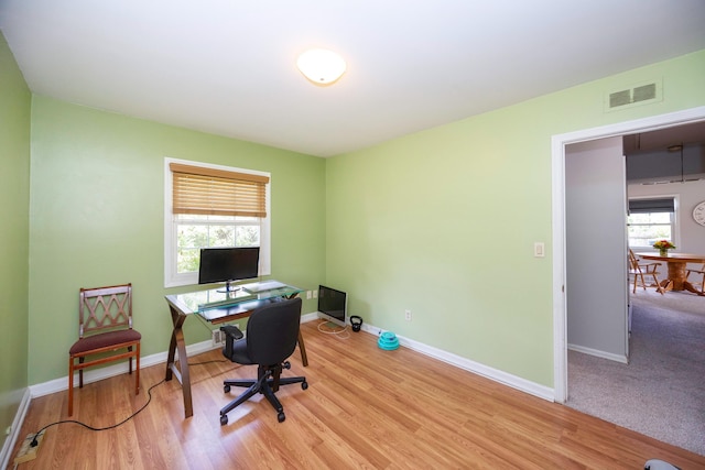 home office featuring a healthy amount of sunlight and light hardwood / wood-style floors