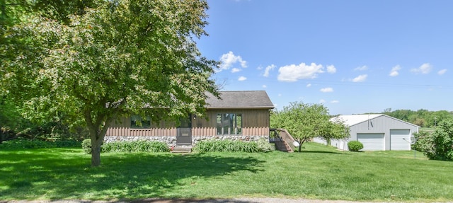 11768 Riker Rd, Litchfield, MI 49252 - back of house with a garage, an outdoor structure, a yard, and board and batten siding