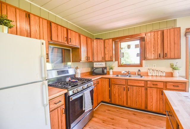 11768 Riker Rd, Litchfield, MI 49252 - kitchen with freestanding refrigerator, stainless steel gas range oven, black microwave, a sink, and wooden ceiling
