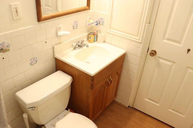 bathroom featuring hardwood / wood-style flooring, toilet, tile walls, and vanity