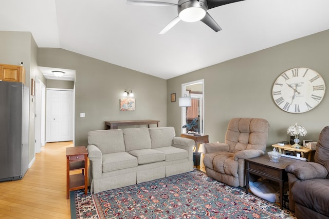 living room with ceiling fan, light hardwood / wood-style floors, and lofted ceiling