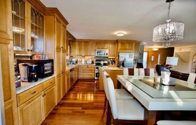 kitchen with hanging light fixtures, dark wood-type flooring, appliances with stainless steel finishes, and a chandelier