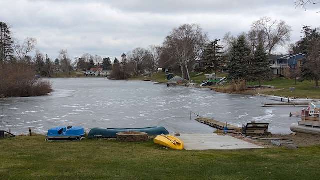 exterior space featuring a lawn, a water view, and a boat dock