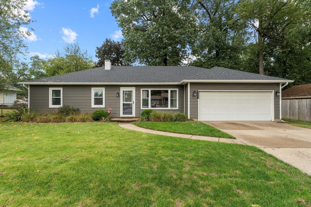 ranch-style home featuring a garage and a front yard