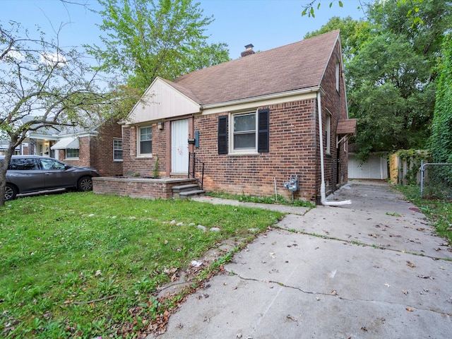 bungalow-style home with a front yard and a garage