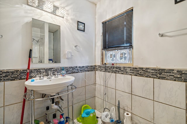 bathroom featuring sink and tile walls