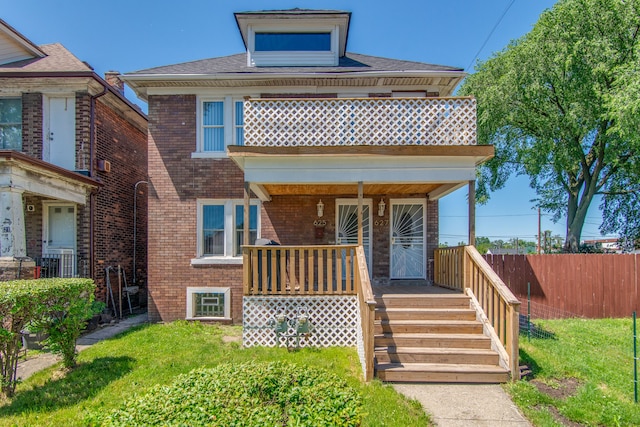 view of front of home featuring a balcony and a front yard