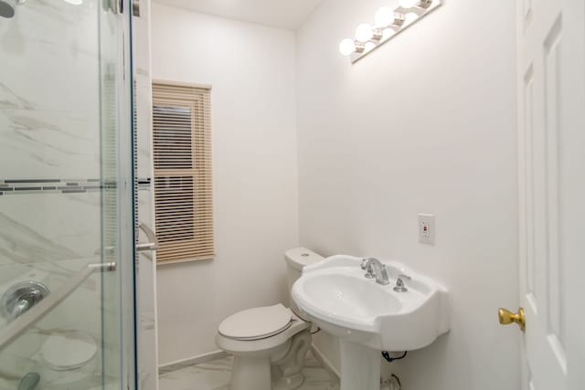 bathroom with sink, a shower with shower door, and toilet